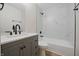 This remodeled bathroom has a gray vanity and a shower/tub combo with white, marble-look tile at 3648 Valley Lake Dr, Indianapolis, IN 46227