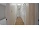 A long hallway has neutral walls, wood-look floors, and white, slatted closet doors at 3648 Valley Lake Dr, Indianapolis, IN 46227