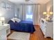 Cozy bedroom with a blue comforter, ceiling fan and white accent furniture at 37 N Arlington Ave, Indianapolis, IN 46219