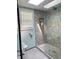 Shower with tile surround, river rock floor and seamless glass door at 37 N Arlington Ave, Indianapolis, IN 46219