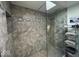 Tiled walk-in shower with seamless glass door, shelving, and river rock base at 37 N Arlington Ave, Indianapolis, IN 46219