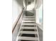 Staircase with wooden railing, carpeting, and a window for natural light at 37 N Arlington Ave, Indianapolis, IN 46219