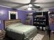 Cozy bedroom featuring purple walls, a ceiling fan, and wooden furnishings at 389 W Poston Rd, Martinsville, IN 46151