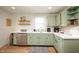 Charming kitchen with light green cabinets, stainless steel appliances, and wood-look flooring at 419 S Oak St, Fortville, IN 46040