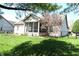 Backyard with a screened-in porch, manicured lawn, and beautiful blossoming tree at 45 Golden Tree Ln, Indianapolis, IN 46227