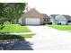 Single-story brick home featuring an attached two-car garage and lush green lawn at 45 Golden Tree Ln, Indianapolis, IN 46227