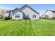 Exterior view of the back of the home with a well-manicured lawn and landscaping at 5083 Castamere Dr, Noblesville, IN 46062