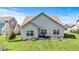 This home has a well-kept lawn, a patio with chairs and a table and the house's light gray exterior at 5083 Castamere Dr, Noblesville, IN 46062