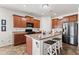 Spacious eat-in kitchen features dark wood cabinets, a kitchen island, and stainless steel refrigerator at 5083 Castamere Dr, Noblesville, IN 46062