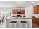 Bright eat-in kitchen with dark wood cabinets, black appliances, and kitchen island with bar seating at 5083 Castamere Dr, Noblesville, IN 46062