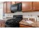 Modern kitchen featuring a black stovetop and microwave, and countertops with beautiful brown cabinets at 5083 Castamere Dr, Noblesville, IN 46062