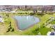 A pond features a fountain and a maintained green lawn, surrounded by a variety of lush trees at 5083 Castamere Dr, Noblesville, IN 46062