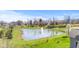A beautiful pond with a fountain is surrounded by a lush green lawn and mature trees, enhancing the serene landscape at 5083 Castamere Dr, Noblesville, IN 46062