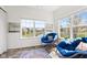 Sunroom with a pond view, flooded with natural light and featuring two plush blue papasan chairs at 5083 Castamere Dr, Noblesville, IN 46062