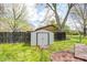 Backyard view showcases a white shed and fenced yard area, complete with green grass and some trees at 509 Nelson Dr, Brownsburg, IN 46112