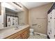 Bathroom with laminate counters, wood cabinets, and shower/tub combo with nautical curtain at 509 Nelson Dr, Brownsburg, IN 46112