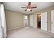 Bright bedroom featuring neutral walls, soft carpet, a ceiling fan, and ensuite bathroom access at 509 Nelson Dr, Brownsburg, IN 46112