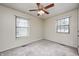 A simple bedroom featuring carpeted floors, neutral walls, and two windows at 509 Nelson Dr, Brownsburg, IN 46112