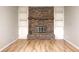 Living room with a brick fireplace, white built-ins, hardwood floors, and neutral paint at 509 Nelson Dr, Brownsburg, IN 46112