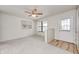 Bright living room features a ceiling fan, a large window, carpeted floors, and a rear entrance at 509 Nelson Dr, Brownsburg, IN 46112