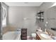 Bathroom features a large bathtub with tile surround, modern fixtures, and a granite countertop vanity at 5157 Climbing Rose Pl, Indianapolis, IN 46254
