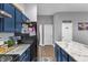Modern kitchen with stainless steel appliances, a large island with marble countertops, and stylish blue cabinetry at 5157 Climbing Rose Pl, Indianapolis, IN 46254