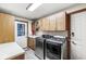 Convenient laundry room with modern washer and dryer, storage cabinets, and utility sink at 5298 Royal Troon Way, Avon, IN 46123