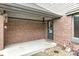 Covered patio with brick wall and a dark door, offering a secluded and inviting outdoor space at 5298 Royal Troon Way, Avon, IN 46123