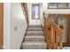 Carpeted staircase with wood railing leading to upper level. Decorative glass front door at 5298 Royal Troon Way, Avon, IN 46123