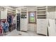 Organized walk-in closet featuring custom shelves, drawers, secure safe and window view to the outdoors at 5298 Royal Troon Way, Avon, IN 46123