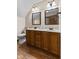 Bathroom featuring double sinks, wood cabinets, a toilet, and laminate floors at 5341 W Stonehaven Ln, New Palestine, IN 46163