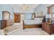 Bedroom with a large bed, side tables, and a dresser, with an ensuite bathroom at 5341 W Stonehaven Ln, New Palestine, IN 46163