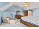 Bedroom features a large bed, vaulted ceilings, and a sitting chair with ottoman at 5341 W Stonehaven Ln, New Palestine, IN 46163