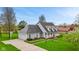 Spacious home with an attached garage and long driveway, surrounded by a beautifully landscaped yard and mature trees at 5341 W Stonehaven Ln, New Palestine, IN 46163