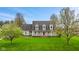 Charming two-story home with a welcoming front porch and a lush green lawn, complemented by blossoming trees at 5341 W Stonehaven Ln, New Palestine, IN 46163