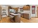 Well-lit kitchen with stainless steel appliances, island with seating, and wood cabinetry at 5341 W Stonehaven Ln, New Palestine, IN 46163