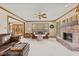 Warm living room featuring a brick fireplace, ceiling fan, and cozy leather furniture at 5341 W Stonehaven Ln, New Palestine, IN 46163