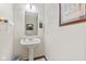Cozy half-bathroom with decorative wall art, a toilet paper holder and trash bin at 5341 W Stonehaven Ln, New Palestine, IN 46163