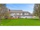 Rear view of a charming home with a large deck, manicured lawn, and mature trees, creating a serene outdoor space at 5341 W Stonehaven Ln, New Palestine, IN 46163