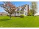 Charming two-story home with a covered porch, complemented by mature trees and a lush green lawn at 5341 W Stonehaven Ln, New Palestine, IN 46163