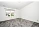 This bedroom features plush carpet, white walls and a big window overlooking the front yard at 5424 Milhouse Rd, Indianapolis, IN 46221