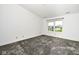 This bedroom features gray carpeting, neutral walls, and a window at 5424 Milhouse Rd, Indianapolis, IN 46221