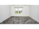 Bedroom with fresh carpet, neutral walls and a view of the front yard through a bright window at 5424 Milhouse Rd, Indianapolis, IN 46221