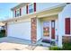 Charming home exterior featuring a two-car garage, brick accents, and a red front door at 5424 Milhouse Rd, Indianapolis, IN 46221