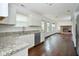 Bright kitchen with white cabinets, granite countertops, stainless steel appliances, and a view into the living room at 5424 Milhouse Rd, Indianapolis, IN 46221