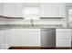 Corner view of the kitchen featuring white cabinetry, stainless steel dishwasher, and granite countertops at 5424 Milhouse Rd, Indianapolis, IN 46221
