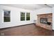 Spacious living room with hardwood floors and a brick fireplace, complemented by large windows at 5424 Milhouse Rd, Indianapolis, IN 46221