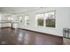 Bright living area connected to a kitchen, featuring large windows and hardwood flooring at 5424 Milhouse Rd, Indianapolis, IN 46221