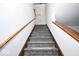 A stairwell with carpeting and wood rails on both sides at 5424 Milhouse Rd, Indianapolis, IN 46221
