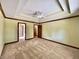 Spacious bedroom features a tray ceiling, fan, neutral carpet, and two entry doors at 5441 Red Hawk Ln, Greenwood, IN 46142